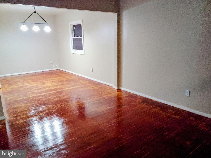 9110 Meadow Heights Road Randallstown, MD 21133 - Photo 9 of 21 an empty room with wooden floor and windows