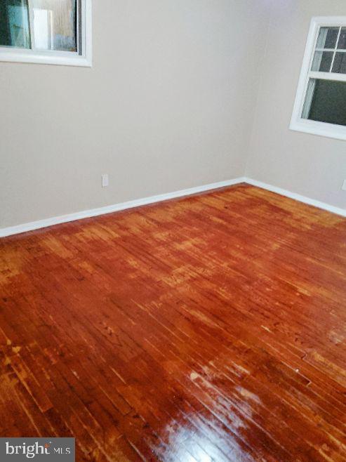 9110 Meadow Heights Road Randallstown, MD 21133 - Photo 10 of 21 an empty room with wooden floor and windows