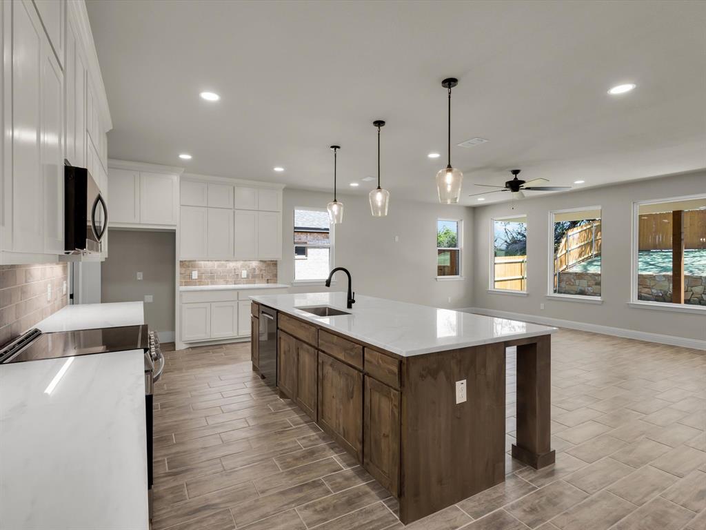 612 Jameson Springtown, TX 76082 - Photo 3 of 13 a kitchen with stainless steel appliances granite countertop a sink a stove and a wooden floors