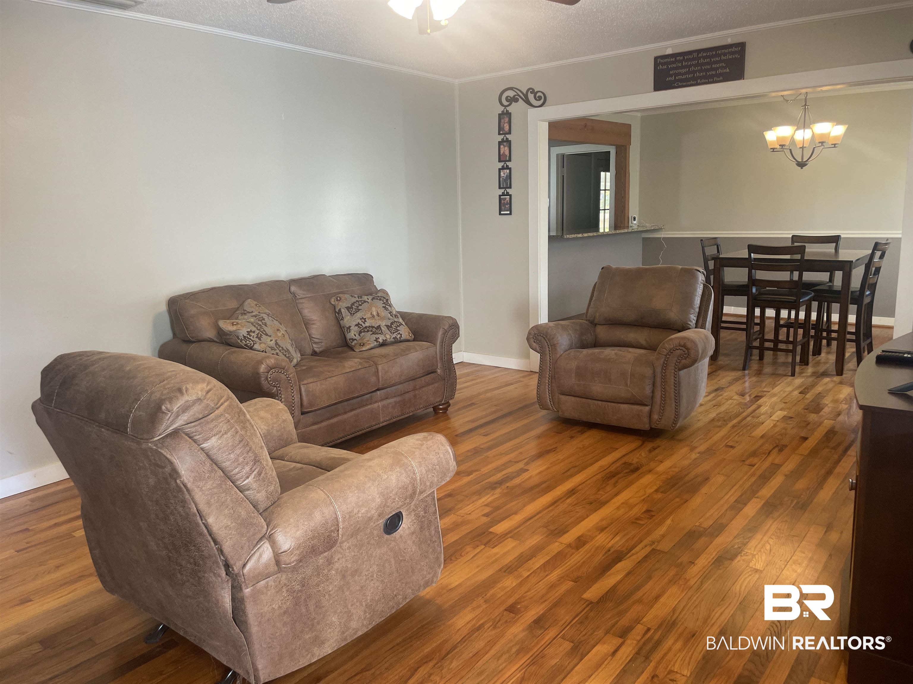 13850 Celeste Road Chunchula, AL 36521 - Photo 6 of 29 Living room featuring a textured ceiling, wood finished floors, ornamental molding, ceiling fan, and a chandelier