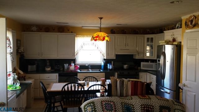 9079 South James River Road Buckingham, VA 23921 - Photo 3 of 16 a kitchen with stainless steel appliances granite countertop a stove top oven a sink a dining table and chairs