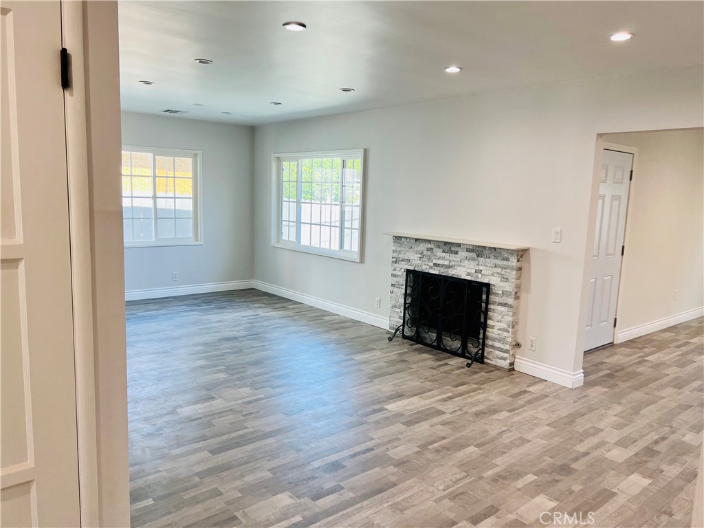 512 Lazard Street San Fernando, CA 91340 - Photo 2 of 3 an empty room with wooden floor fireplace and windows