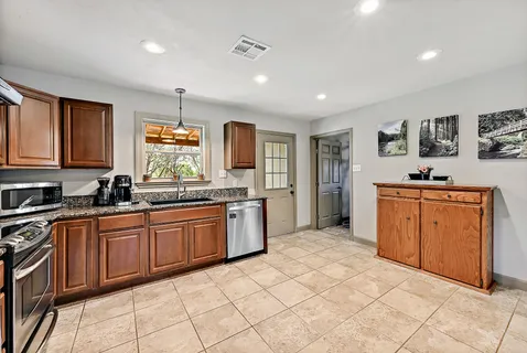 a kitchen with stainless steel appliances granite countertop a stove sink and cabinets