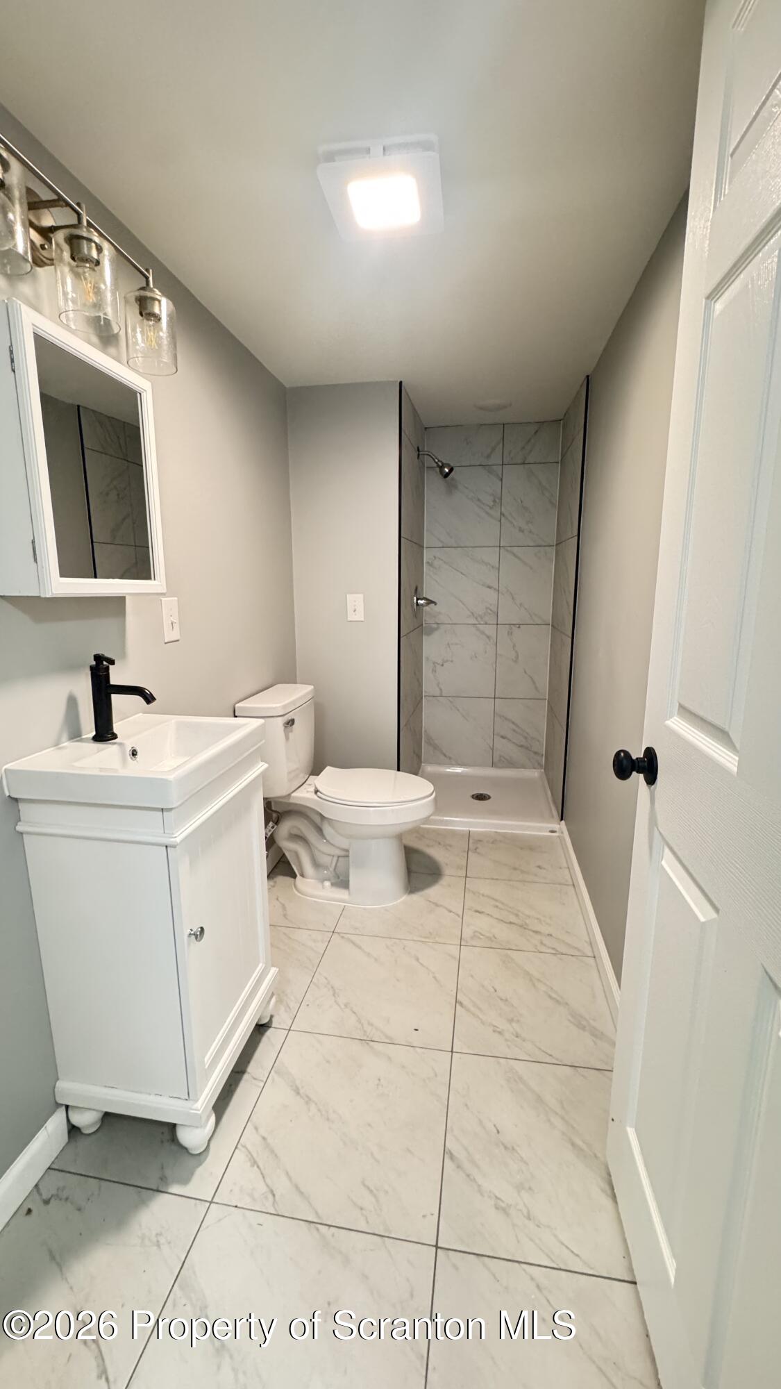 23-25 Shannon Street Simpson, PA 18407 - Photo 11 of 17 a bathroom with a sink toilet and mirror