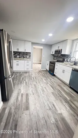 a kitchen with stainless steel appliances granite countertop a refrigerator sink and stove