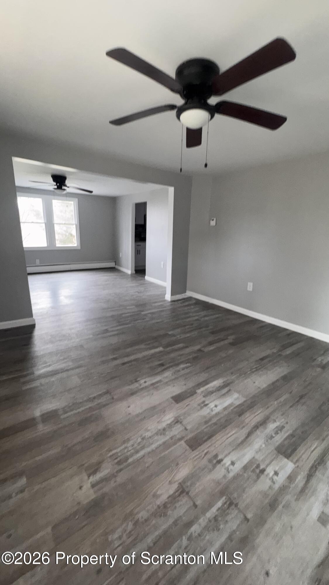 23-25 Shannon Street Simpson, PA 18407 - Photo 5 of 17 a view of an empty room with wooden floor and windows