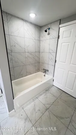a spacious bathroom with a bathtub and a shower