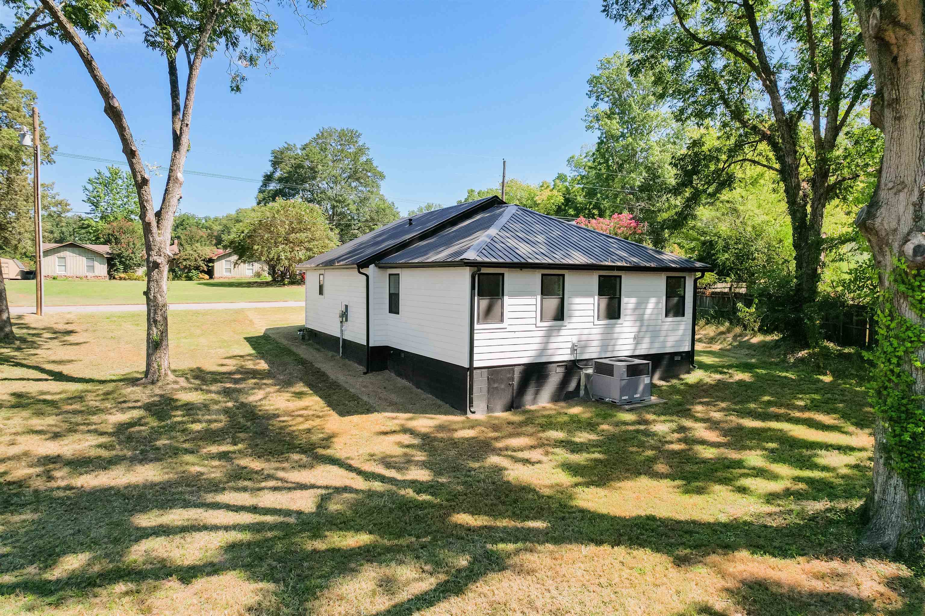135 West 3rd Street Henderson, TN 38340 - Photo 25 of 31 View of side of home featuring a yard and a metal roof