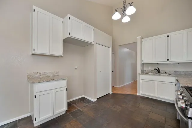 a kitchen with white cabinets and white appliances