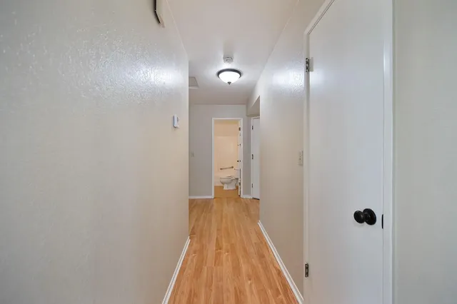 a view of a hallway with wooden floor