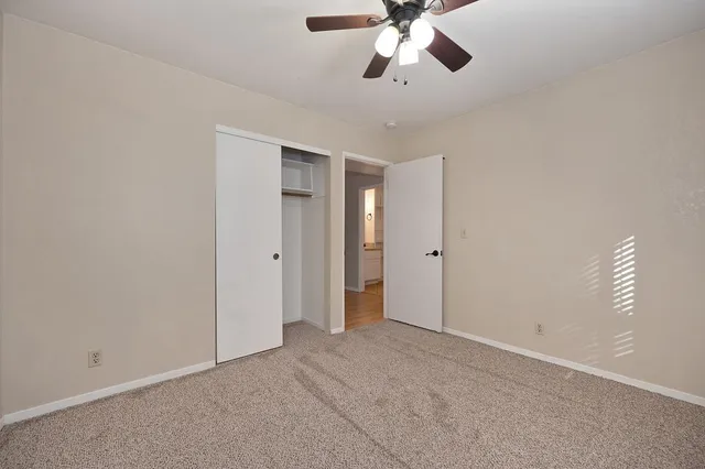 a view of an empty room with a chandelier fan
