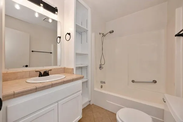a bathroom with a granite countertop sink toilet and shower