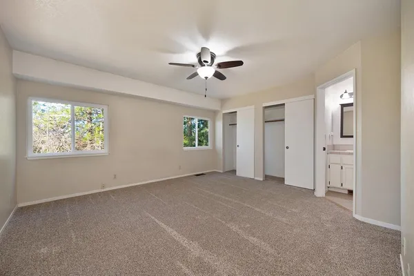 an empty room with fan and windows