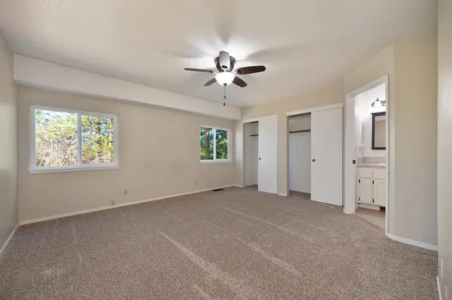 an empty room with fan and windows