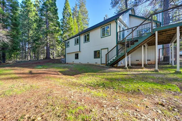 a view of a house with backyard and sitting area