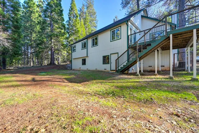 a view of a house with backyard and sitting area