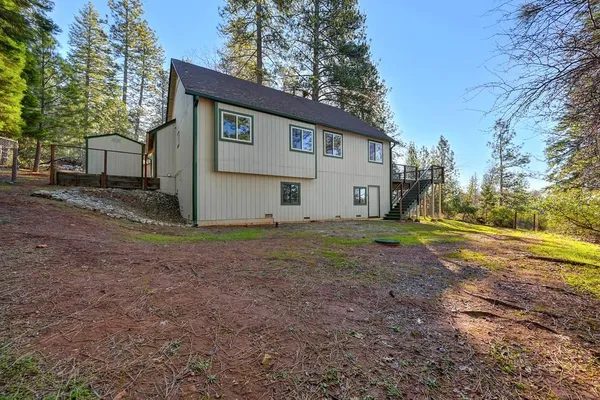 a view of a house with backyard and tree