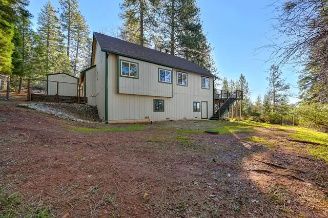 a view of a house with backyard and tree