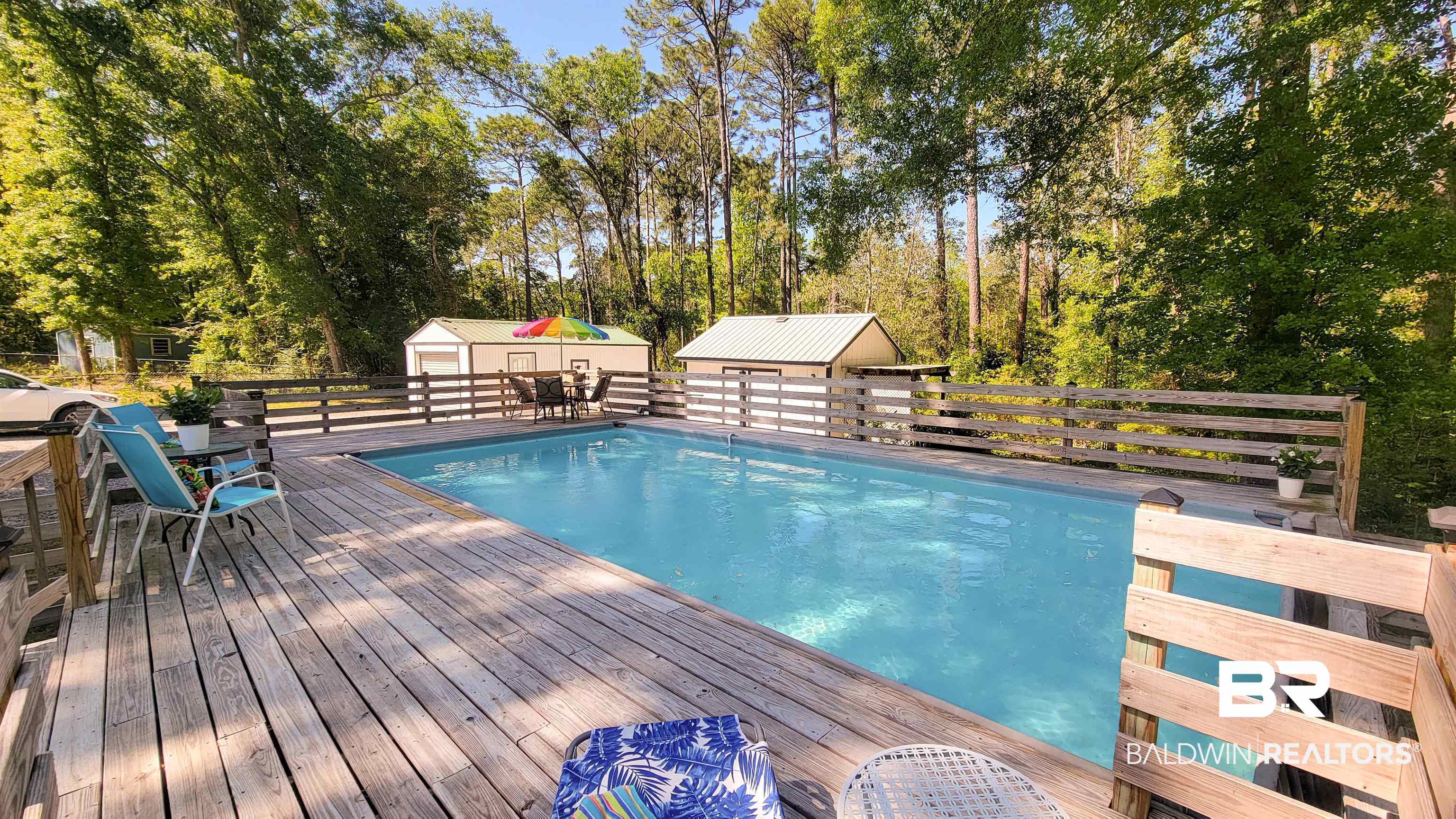9902 Clarke Ridge Road Foley, AL 36535 - Photo 49 of 61 View of swimming pool featuring a storage shed, a deck, outdoor dining area, an outdoor structure, and a fenced in pool