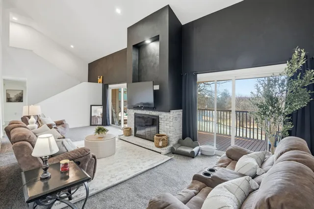 a living room with furniture fireplace and a large window