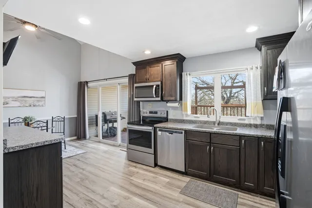 a large kitchen with stainless steel appliances granite countertop a lot of counter space and wooden floor