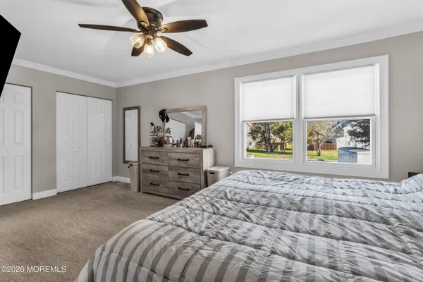 a bedroom with a bed dresser and a window