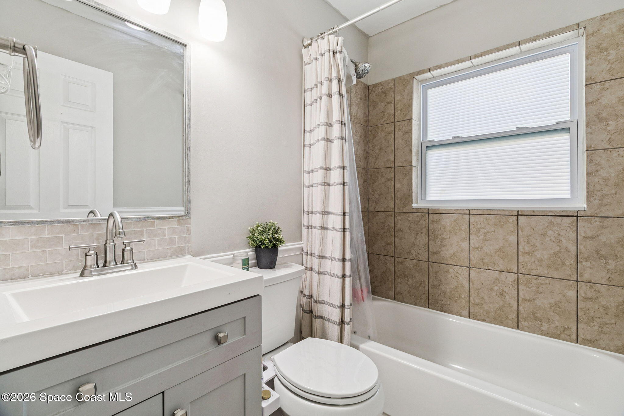 207 2nd Street Merritt Island, FL 32953 - Photo 11 of 19 a bathroom with a sink a toilet a window and shower