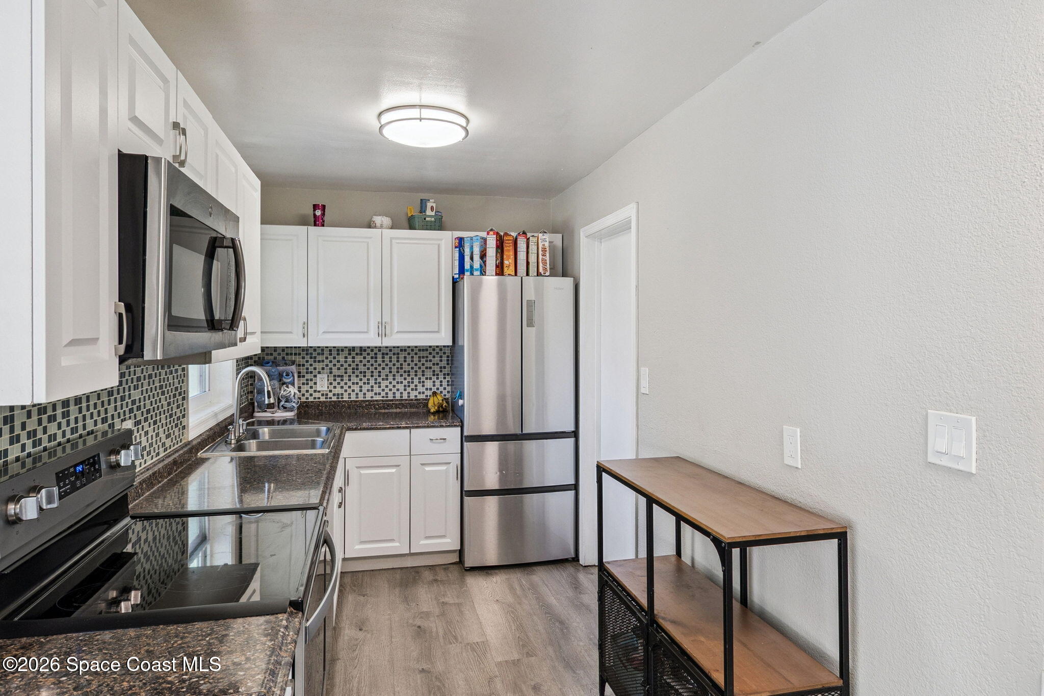 207 2nd Street Merritt Island, FL 32953 - Photo 7 of 19 a kitchen with granite countertop a refrigerator stove and sink