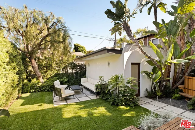 a view of a white house with a yard and sitting area