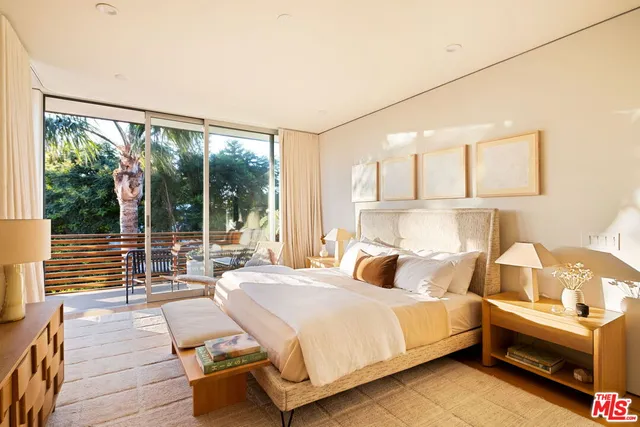 a bedroom with a bed and a large window with outer view