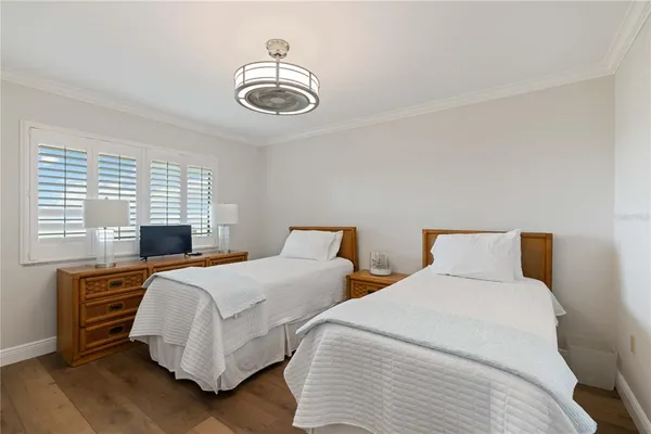 a bedroom with two beds and a chandelier