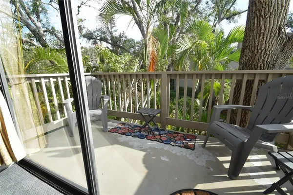 a view of a balcony with chair and floor to ceiling window