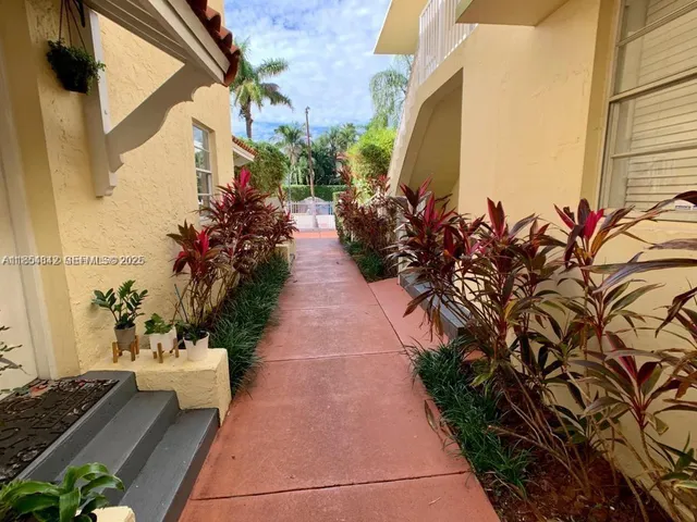 a view of a pathway with a flower garden
