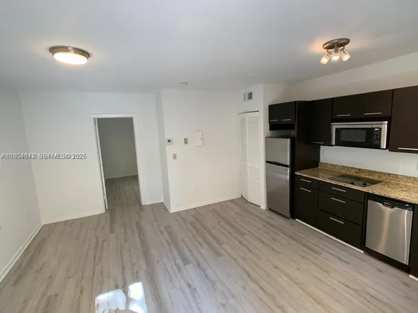 a kitchen with a refrigerator and a stove top oven