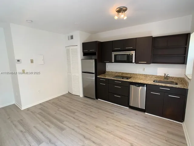 a kitchen with stainless steel appliances granite countertop a refrigerator and a sink