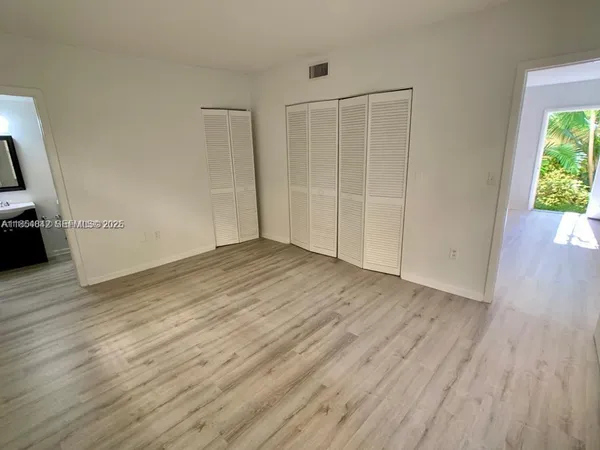 an empty room with wooden floor and a window