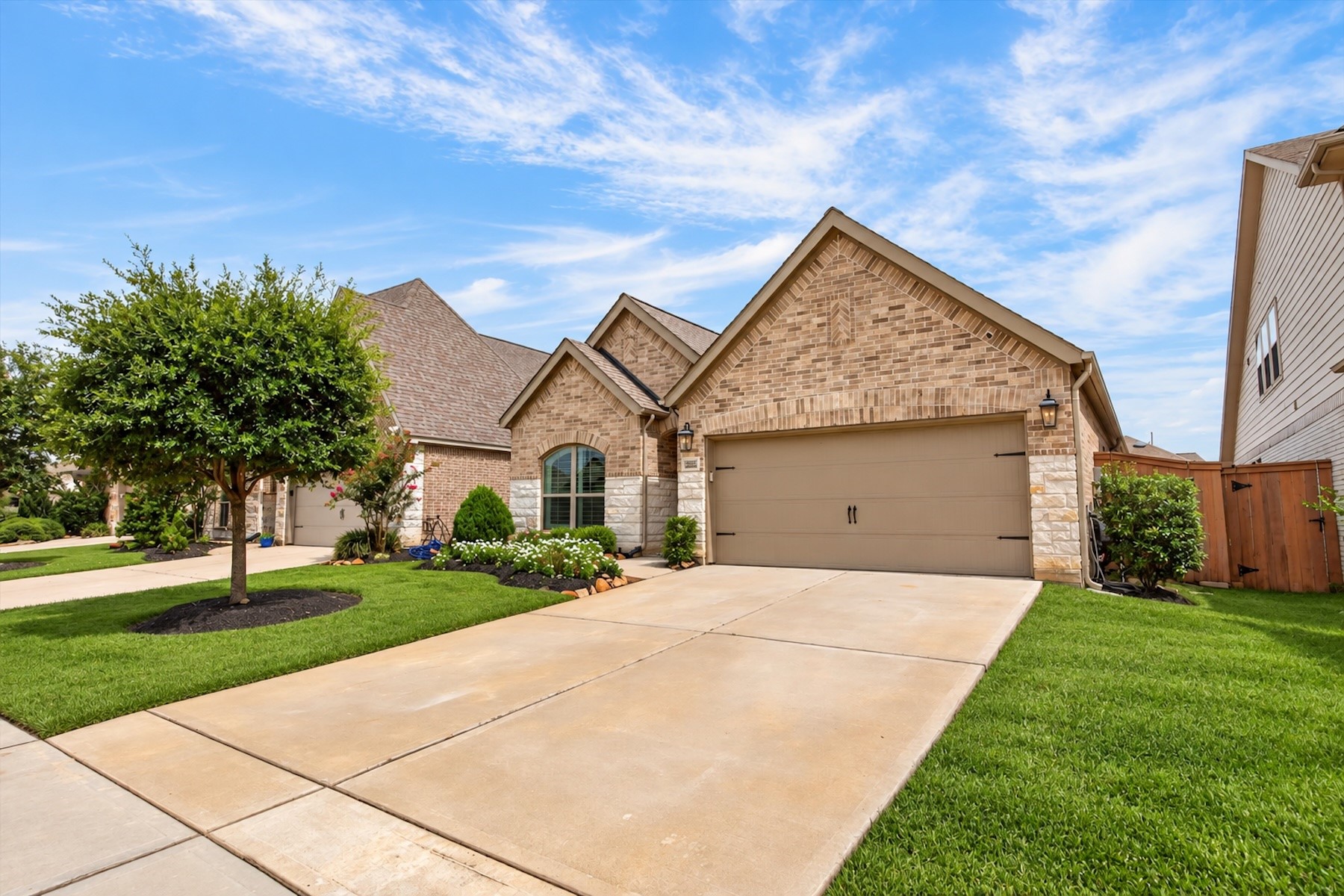 23026 Needle Grass Road Katy, TX 77493 - Photo 2 of 33 Spacious driveway, two-car garage, and charming brick-and-stone elevation.