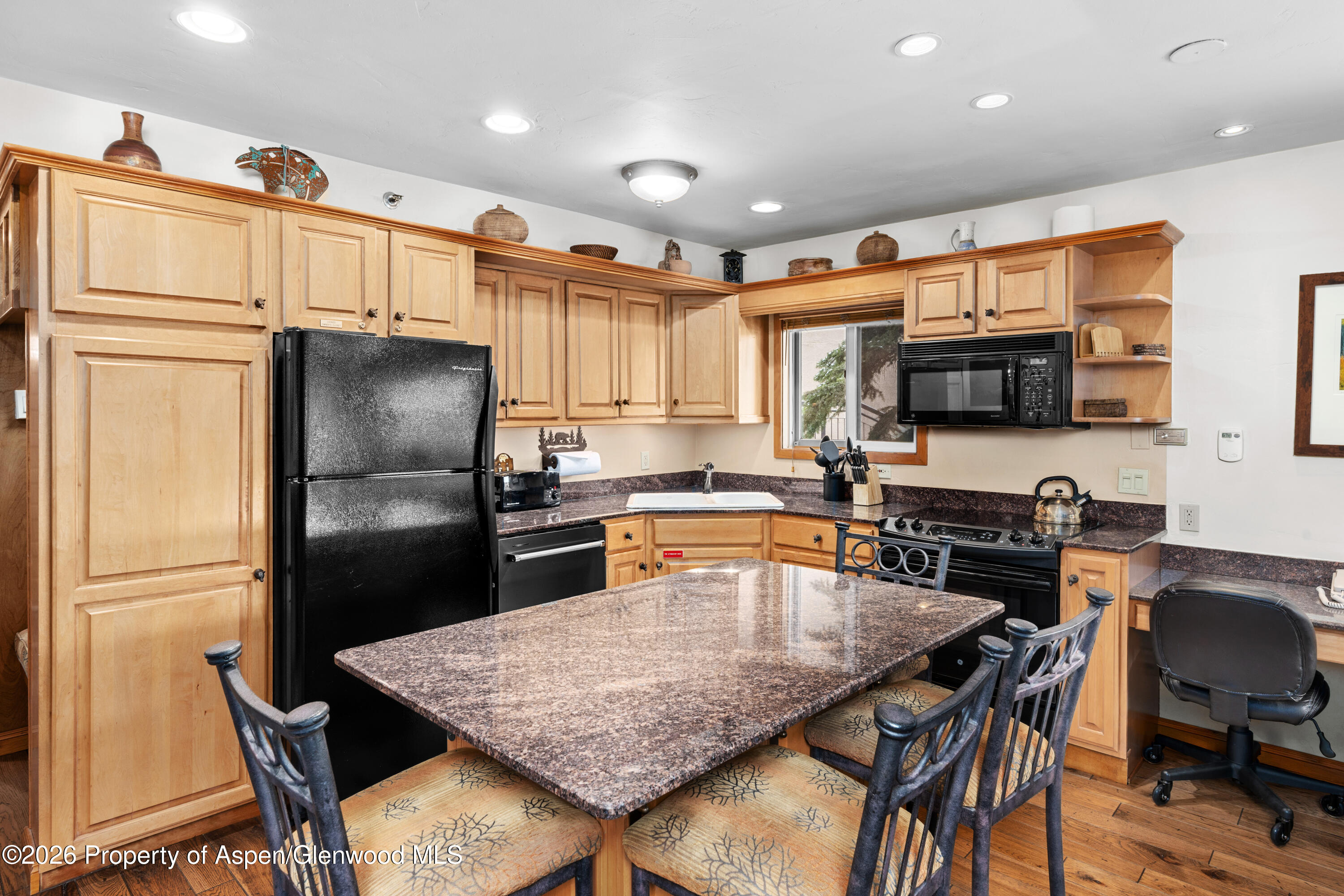 400 Wood Road, Unit 2111H Snowmass Village, CO 81615 - Photo 2 of 16 a kitchen with granite countertop a refrigerator stove microwave and cabinets