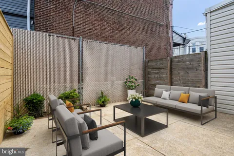 a patio with patio couch and potted plants