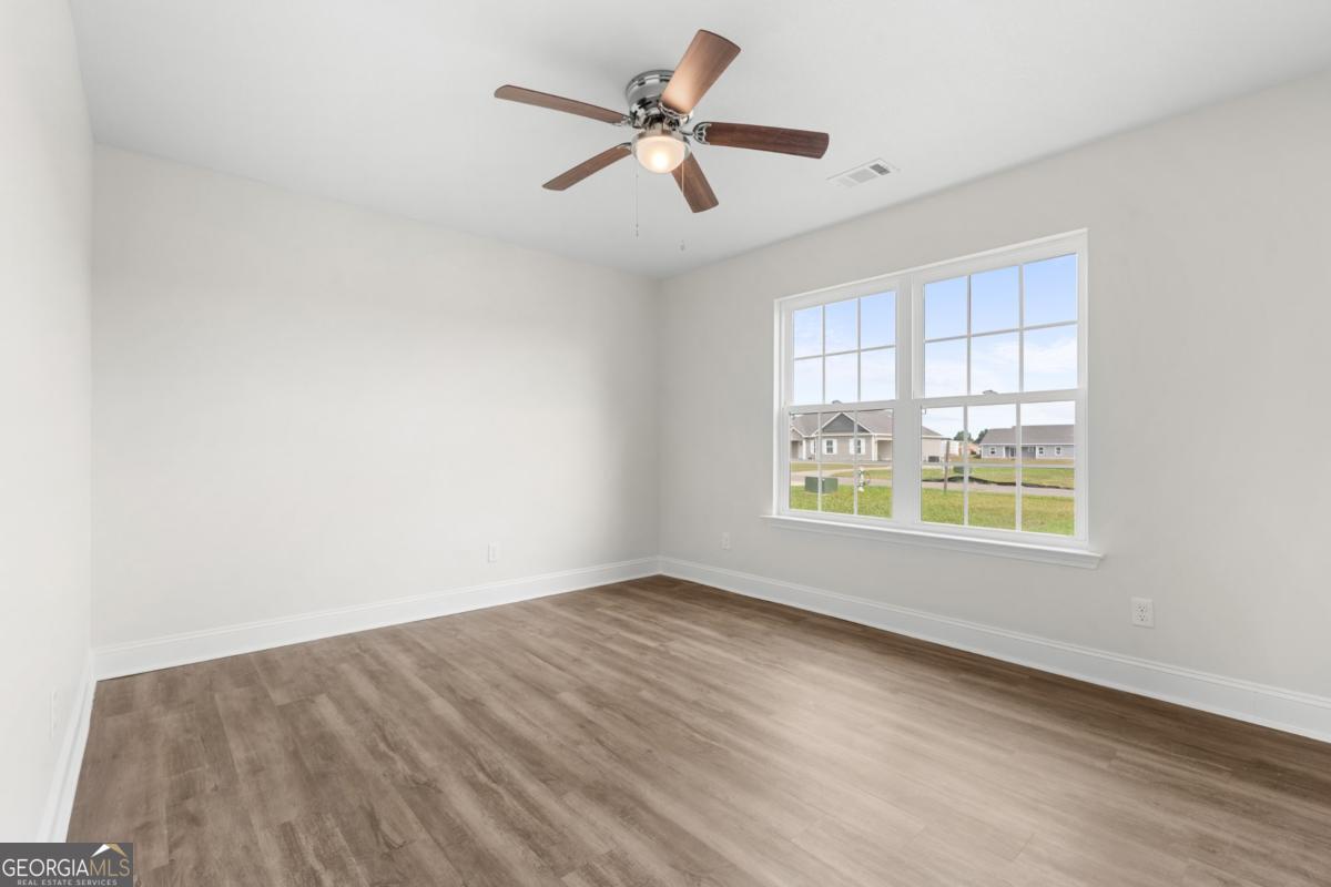 909 Ryegrass Road, Unit 81 Statesboro, GA 30458 - Photo 12 of 23 wooden floor in an empty room with a window