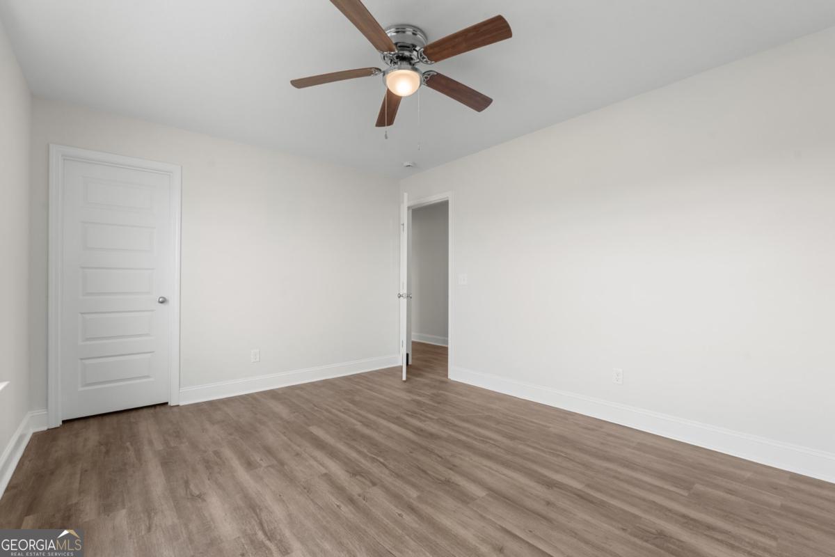 909 Ryegrass Road, Unit 81 Statesboro, GA 30458 - Photo 13 of 23 an empty room with wooden floor and ceiling fan