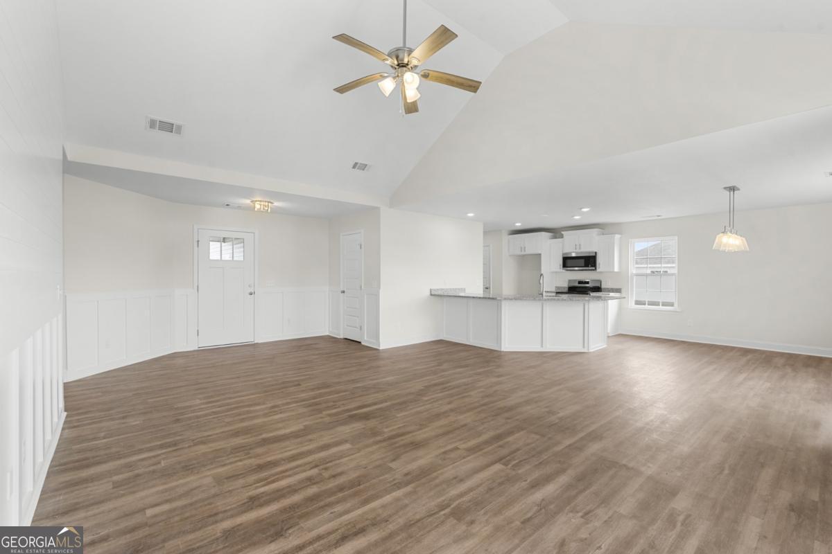 909 Ryegrass Road, Unit 81 Statesboro, GA 30458 - Photo 5 of 23 a view of empty room with wooden floor and kitchen view