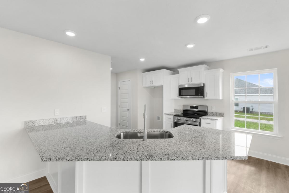 909 Ryegrass Road, Unit 81 Statesboro, GA 30458 - Photo 7 of 23 a kitchen with stainless steel appliances granite countertop a sink a stove and a granite counter tops