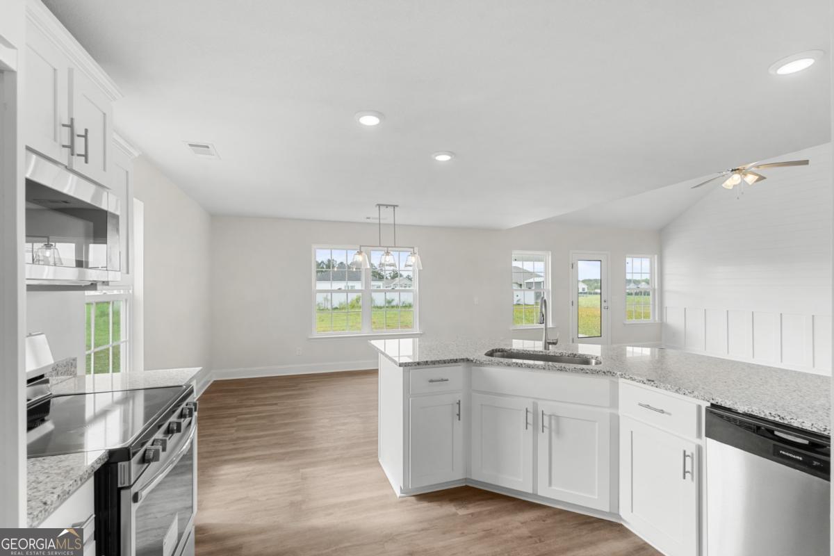 909 Ryegrass Road, Unit 81 Statesboro, GA 30458 - Photo 8 of 23 a kitchen with stainless steel appliances white cabinets and wooden floor