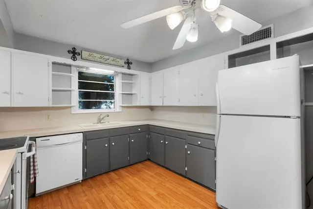 a kitchen with a refrigerator sink and cabinets