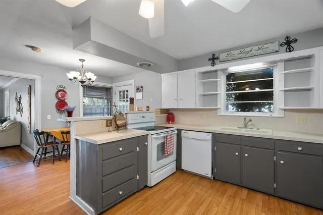 a kitchen with a sink cabinets and wooden floor