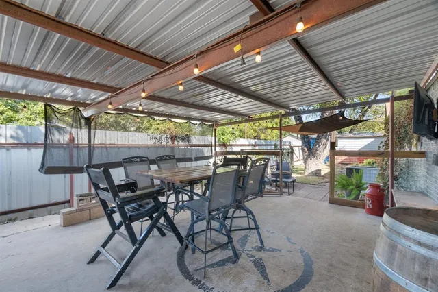 a view of a patio with table and chairs barbeque potted plants and large tree