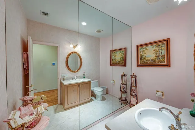 a bathroom with a toilet a sink and a mirror