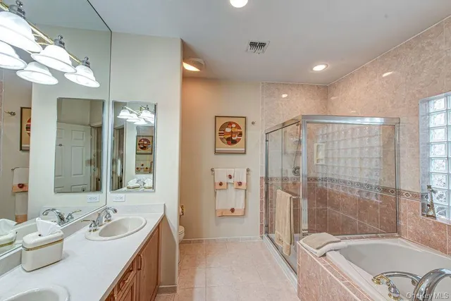 a bathroom with a granite countertop tub sink a mirror a shower and vanity