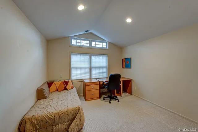 a view of a workspace with furniture and a window